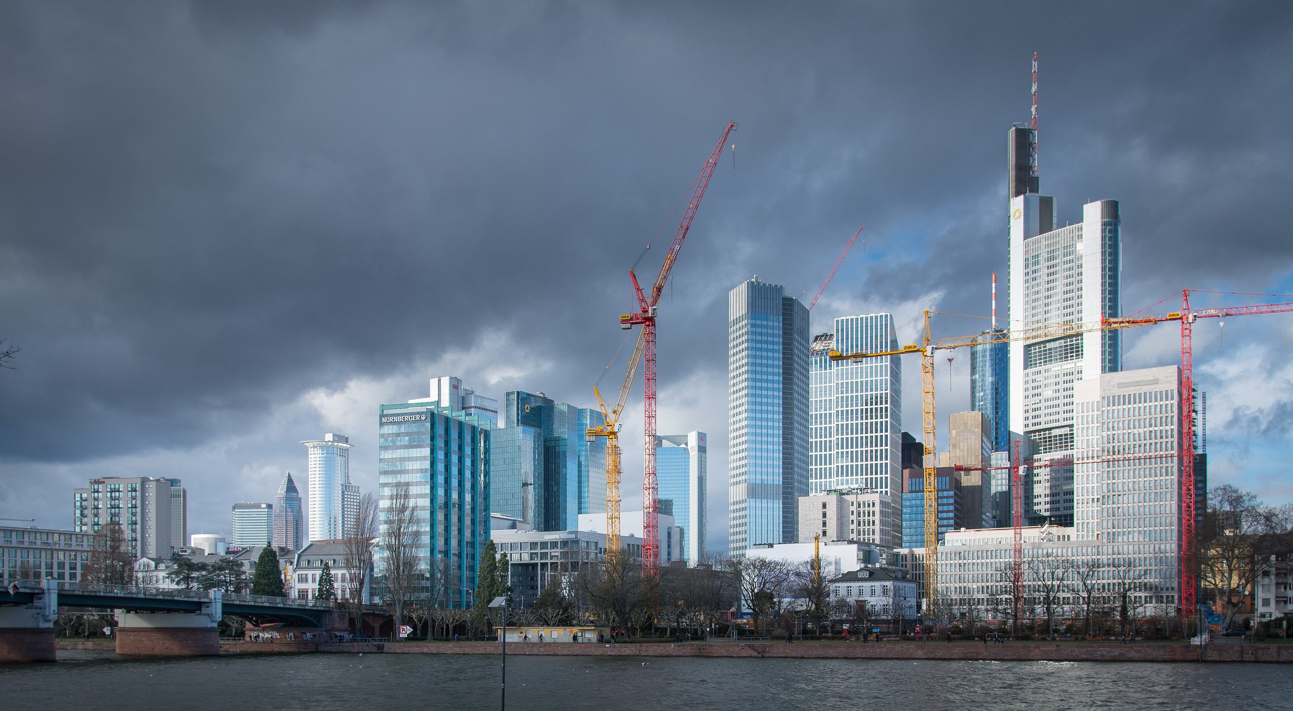 Frankfurter Skyline am Main mit Baukränen vor den Hochhäusern