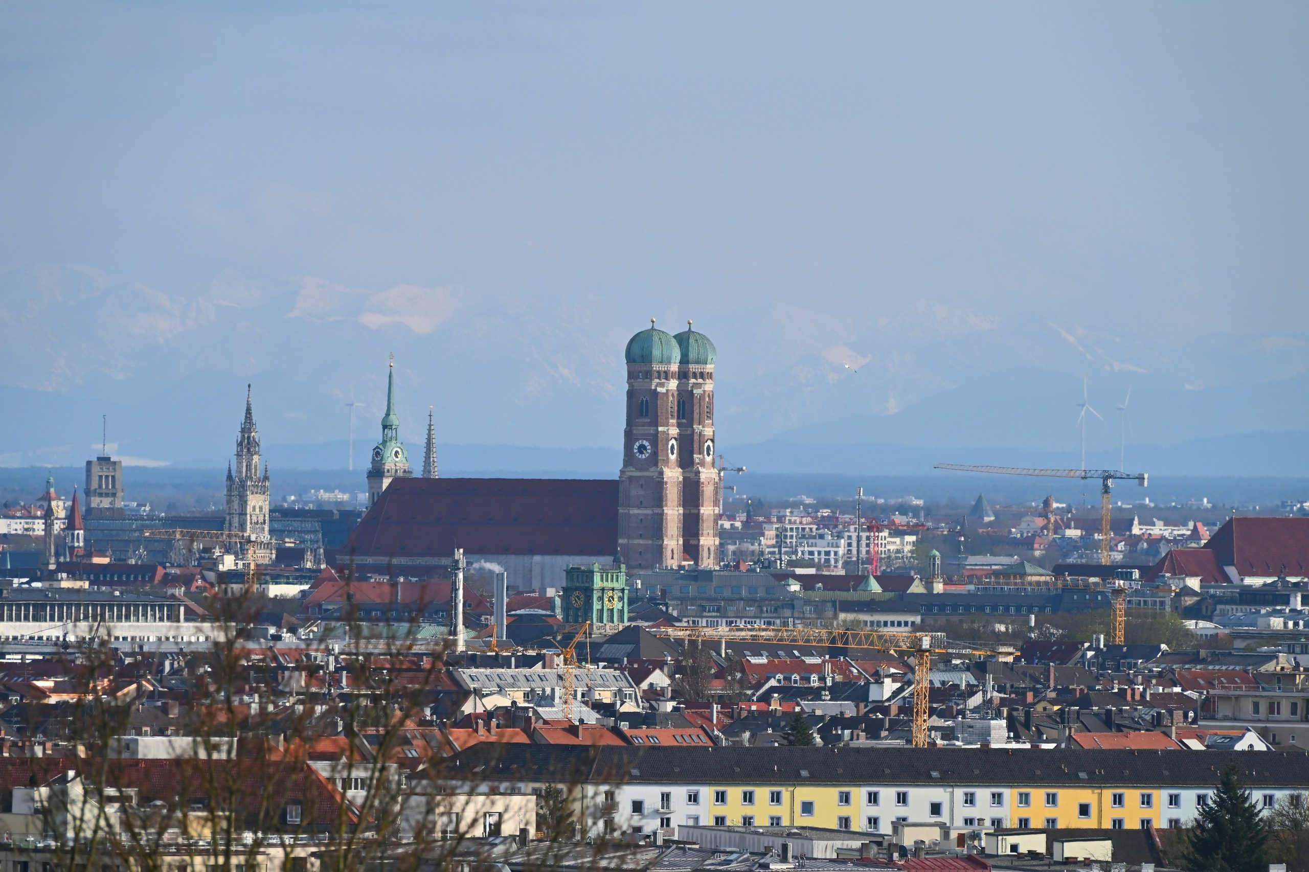 Münchner Altstadt mit Frauenkirche und Baukränen vor den Alpen