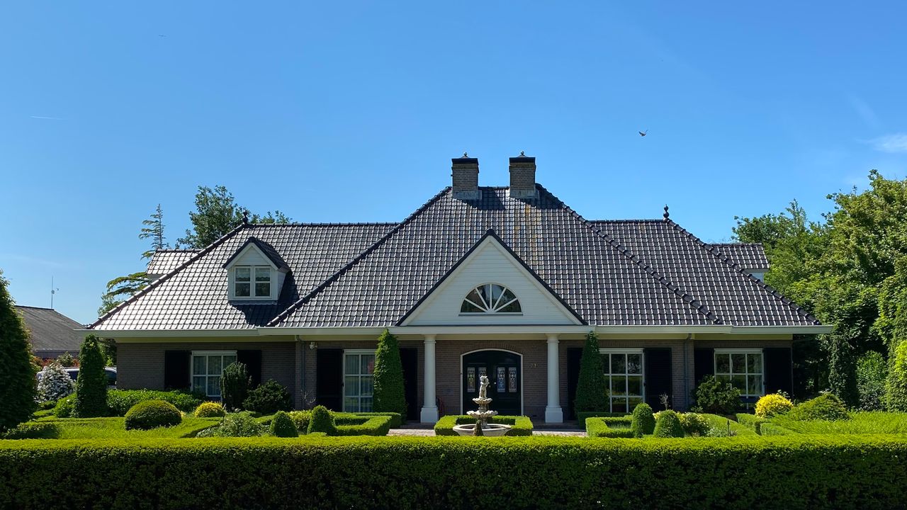 Ebenerdiger Bungalow mit Säulenportal, Buchsgarten und Brunnen